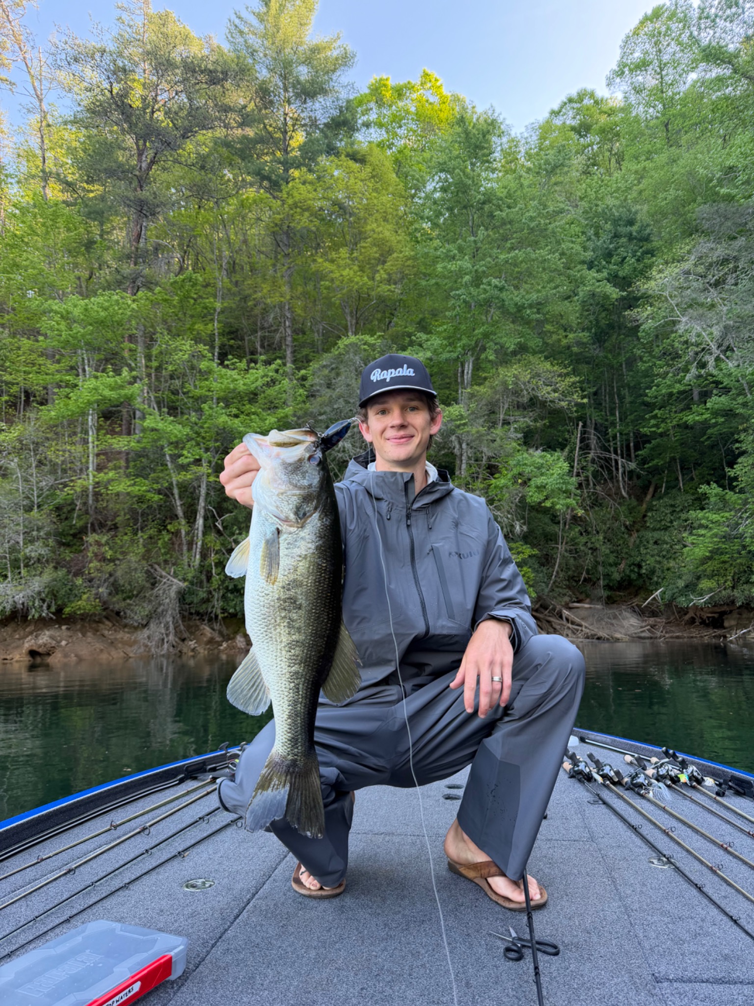 Walker Guides holding a largemouth bass aboard a fishing boat